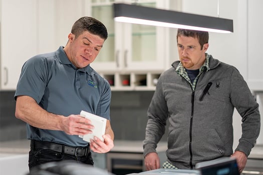 Cabinet IQ founder showing sample piece to employee